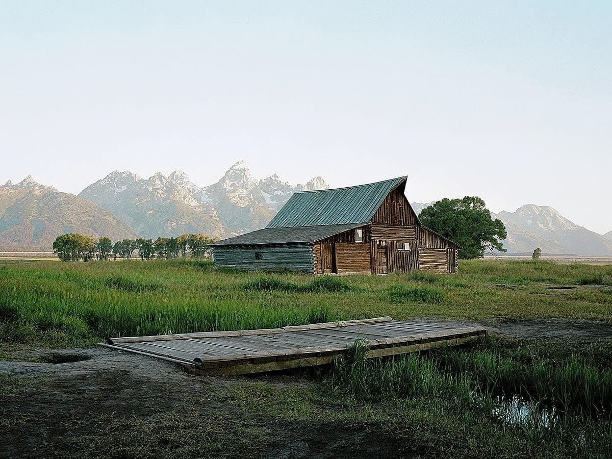 Picture Peddler Wyoming Summer by Sol Rapson Grand Tetons Mountain Range Old West Barn and Bridge Landscape Photograph Art Print Poster Image and Overall Size is 16x20 Inches